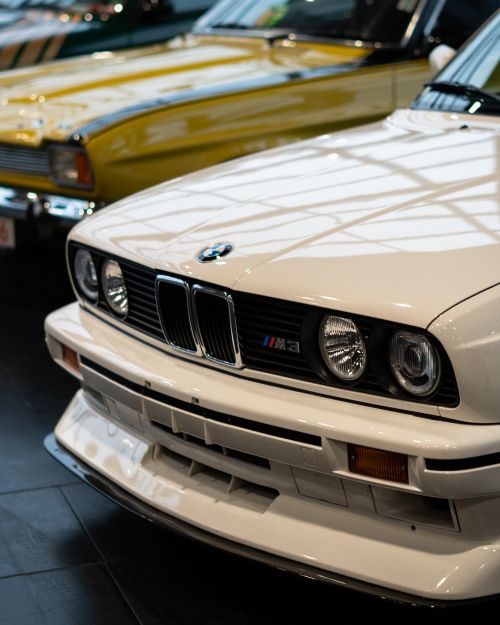 Free A vintage BMW M3 displayed in a car showroom with classic cars. Stock Photo