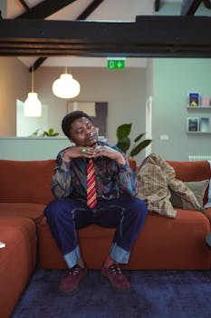 Stylish adult in vibrant attire posing indoors with modern decor. Captured in England.