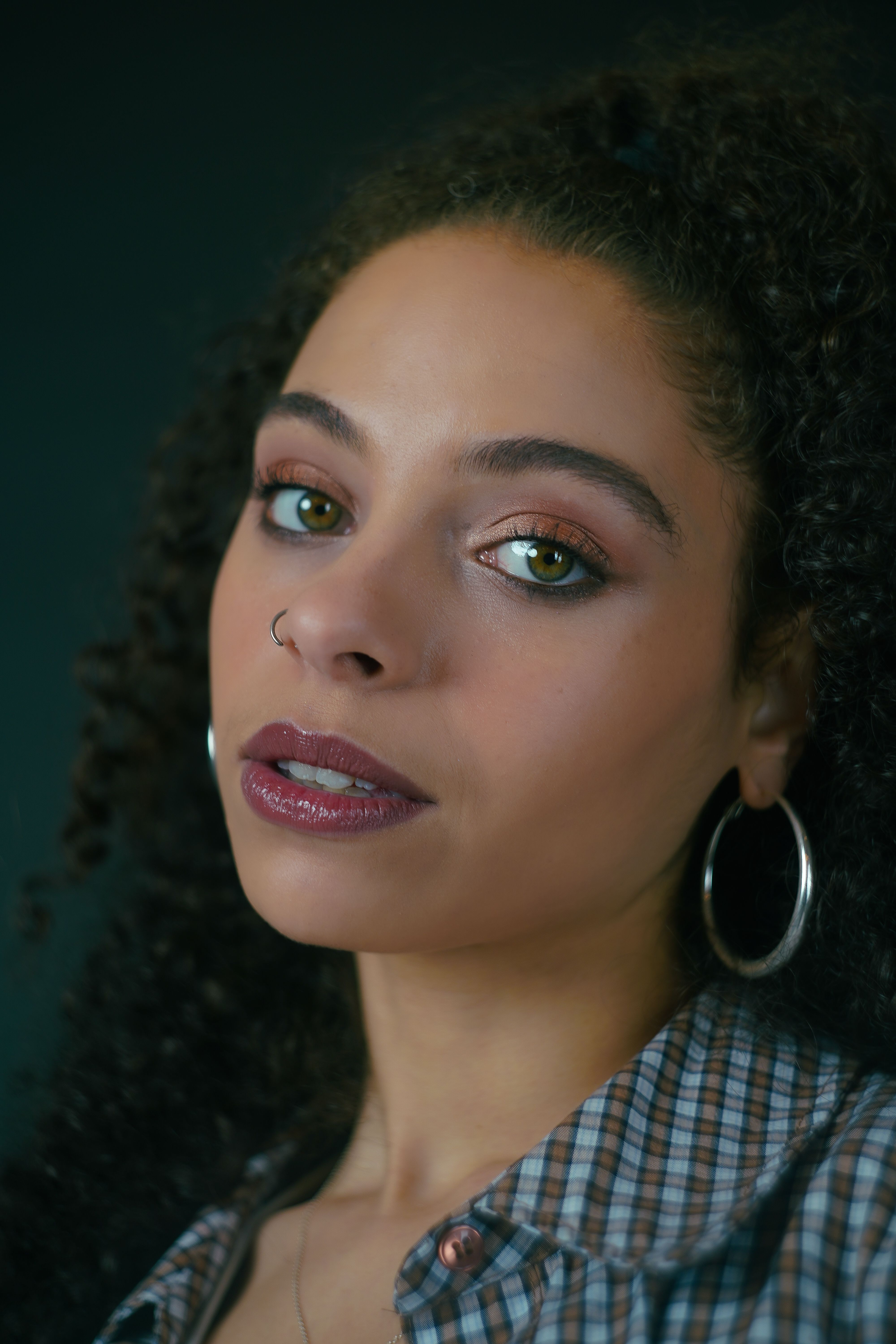 Elegant Portrait of a Young Woman with Curly Hair · Free Stock Photo