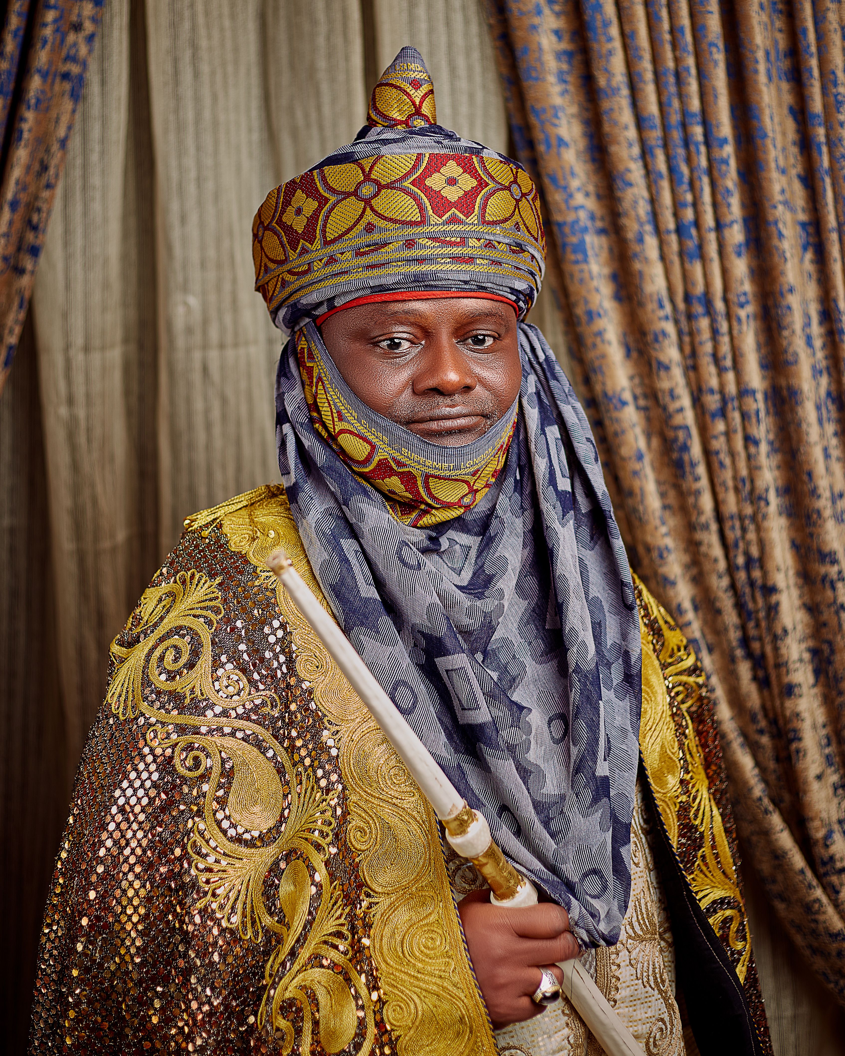 Portrait of a man in ornate traditional African clothing and headwear.