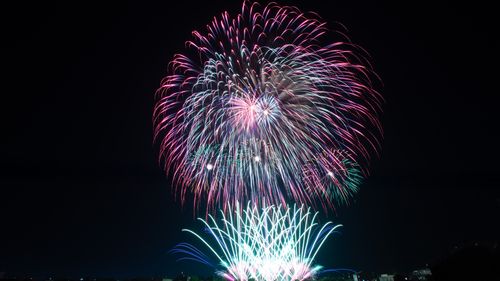 Free Colorful fireworks burst and illuminate the night sky, celebrating a festive occasion. Stock Photo