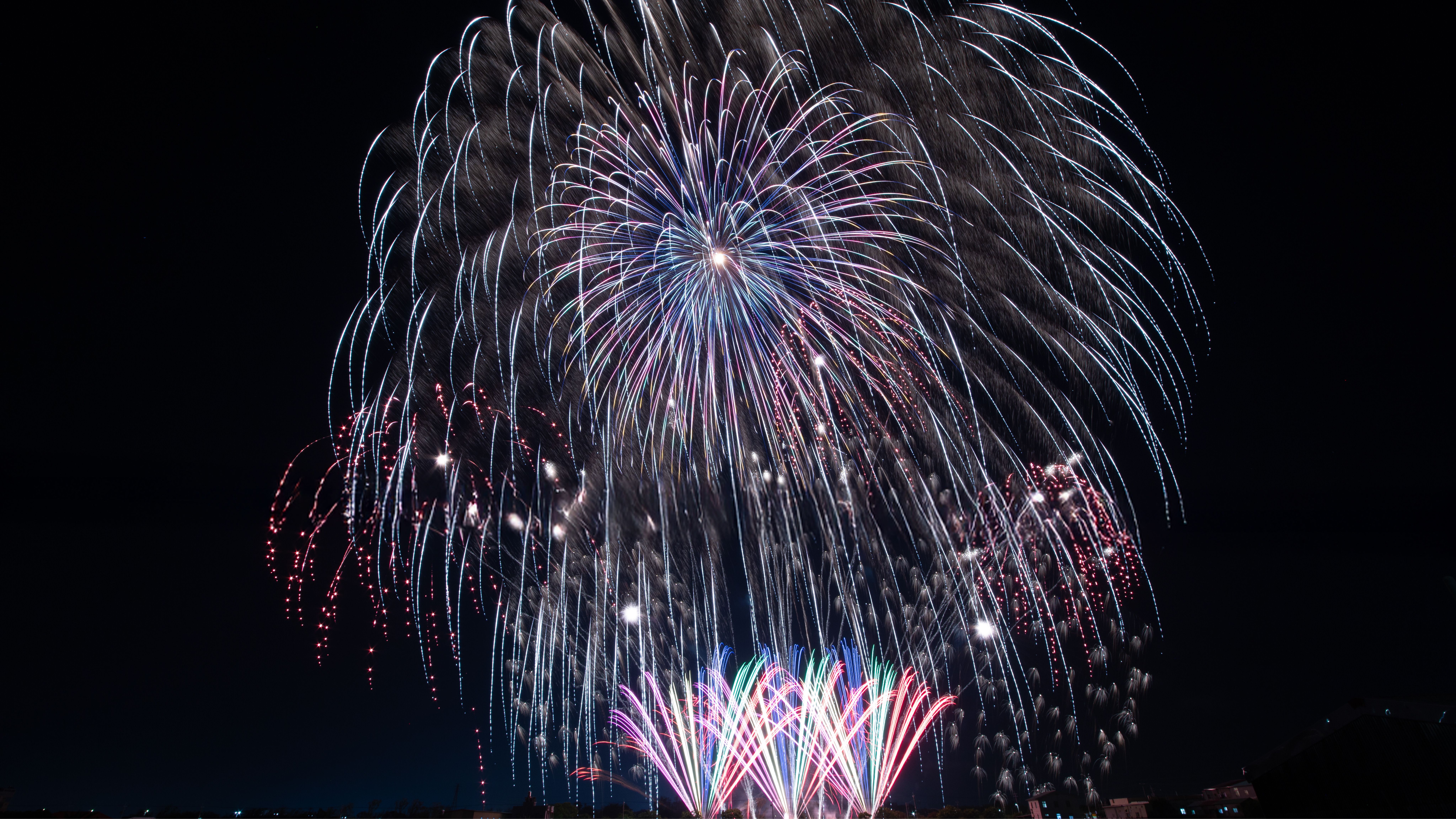 Vibrant fireworks illuminating the night sky in a colorful and dramatic display.