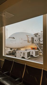 Emirates Airbus A380 boarding at Houston airport viewed from terminal window.