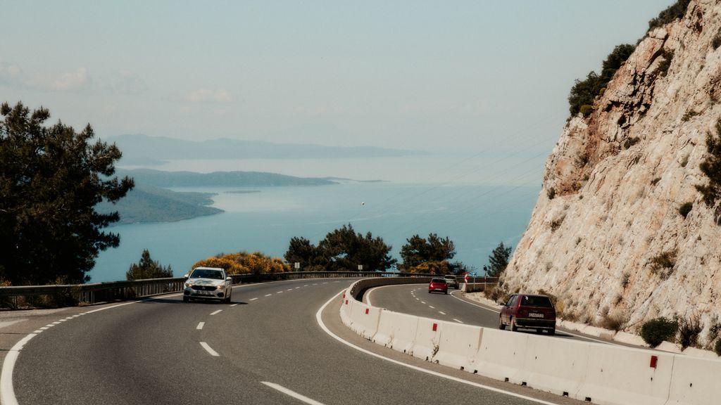 Une voiture sur une route côtière sinueuse en bord de mer