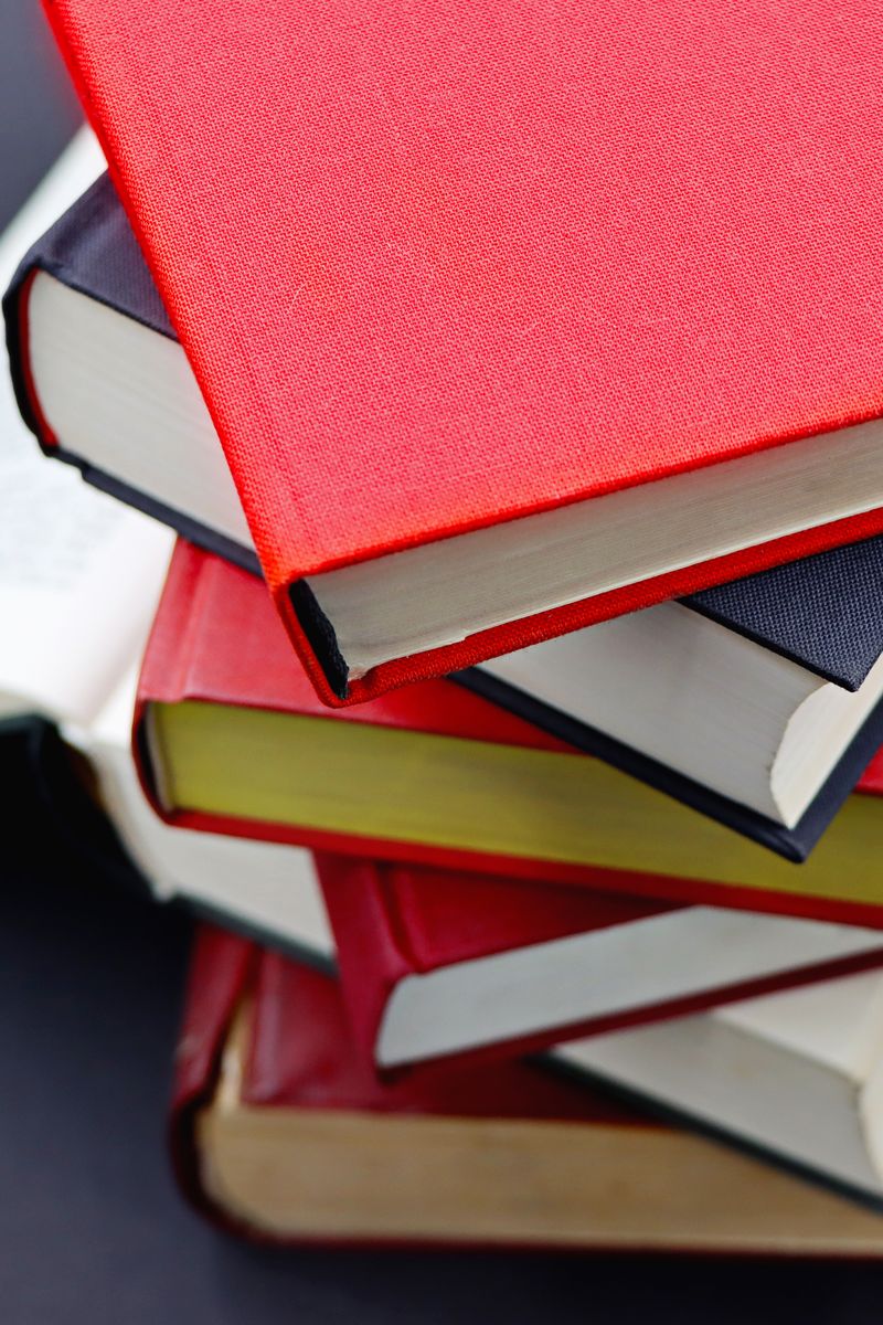 Pile of assorted hardcover books with colorful covers, perfect for study or literature themes. Pile of assorted hardcover books with colorful covers, perfect for study or literature themes.