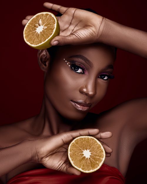 Free Artistic portrait of a woman with oranges, emphasizing beauty and elegance. Stock Photo