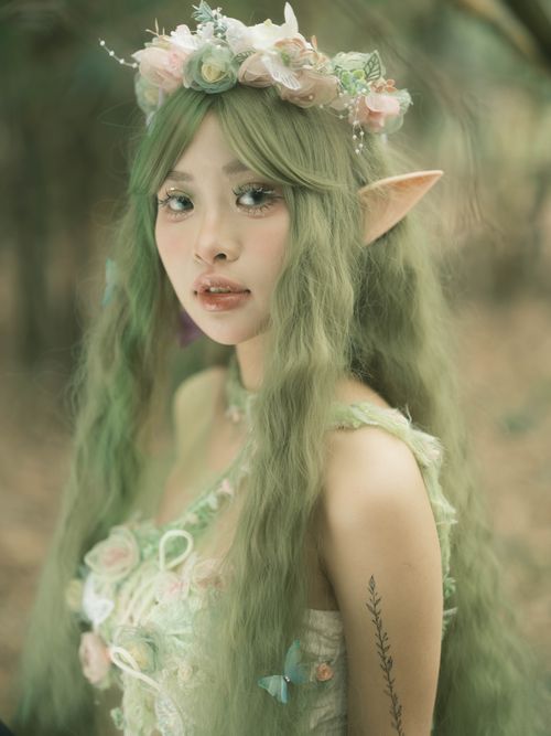 Free Magical fairy in a forest setting adorned with floral crown and elf-like features. Stock Photo