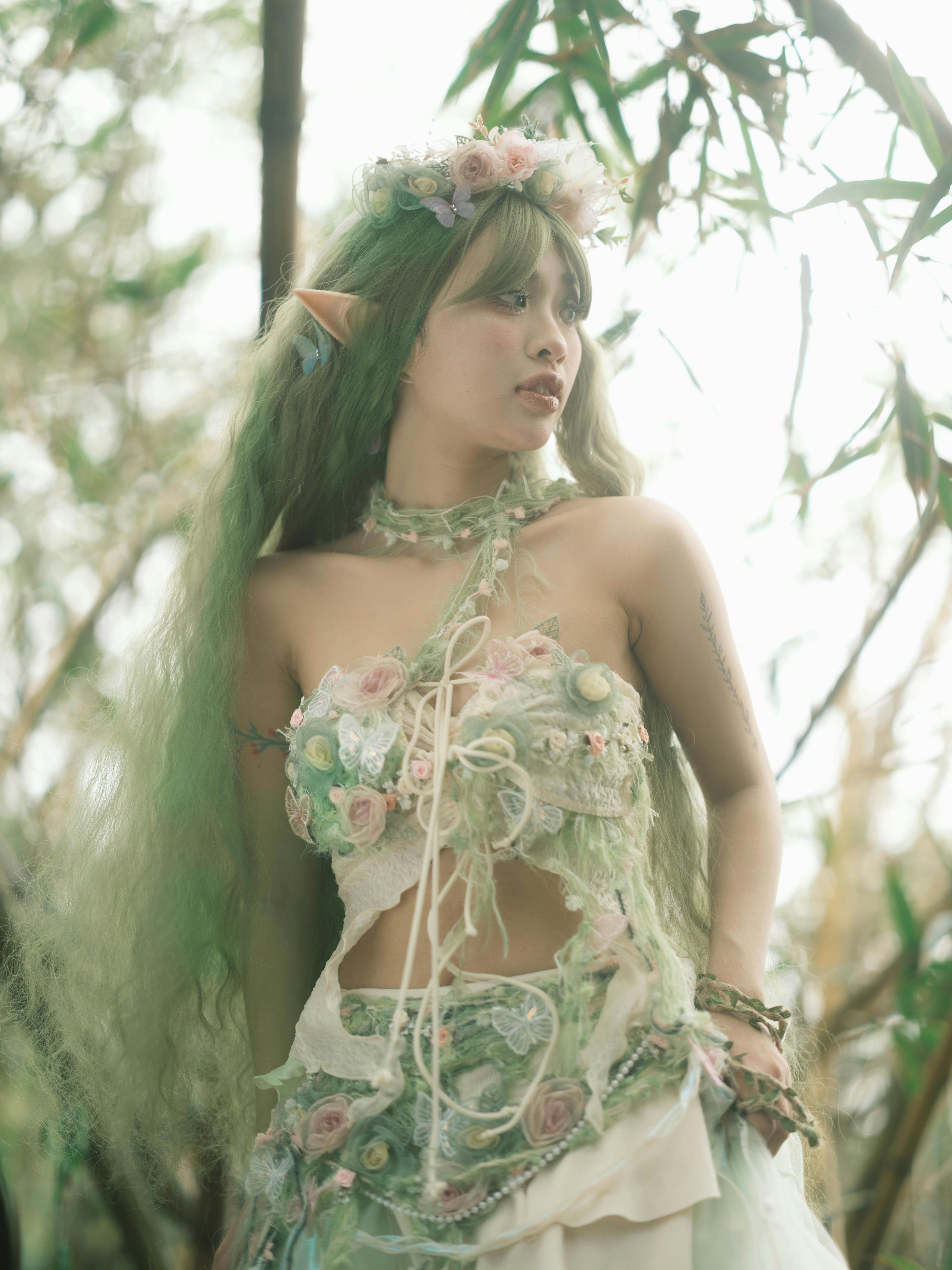 A mystical elf character in a forest, wearing floral attire and accessories, adds fantasy charm.