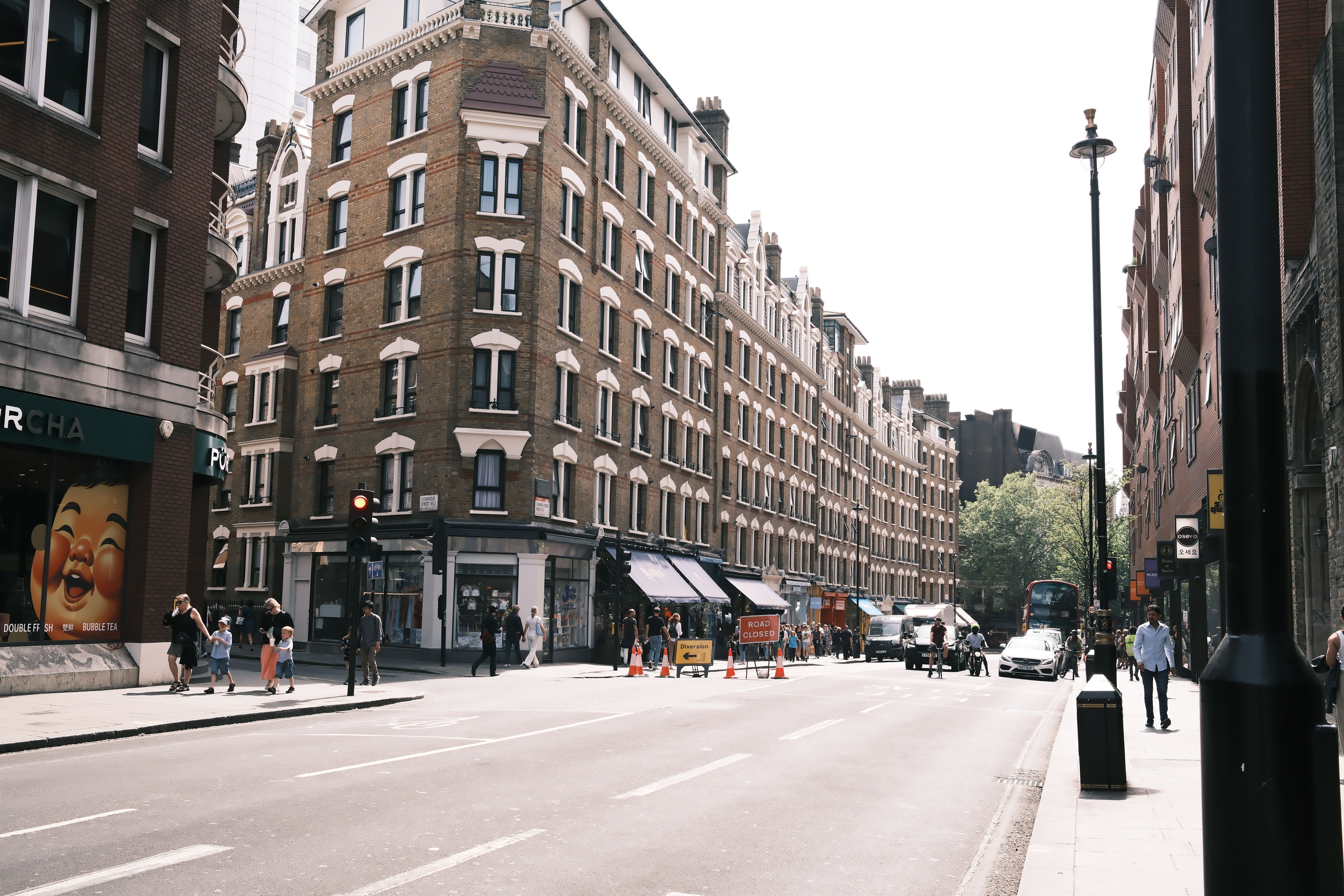 Vibrant street view in central London with classic architecture and bustling activity.