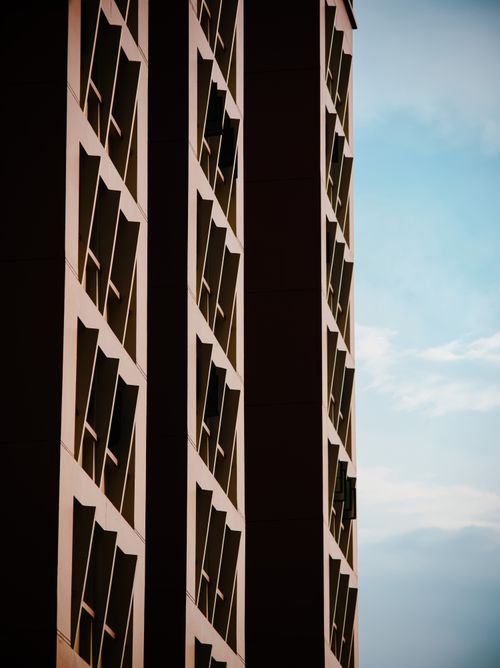 Free View of a modern skyscraper showcasing its angular, geometric facade against a clear blue sky. Stock Photo