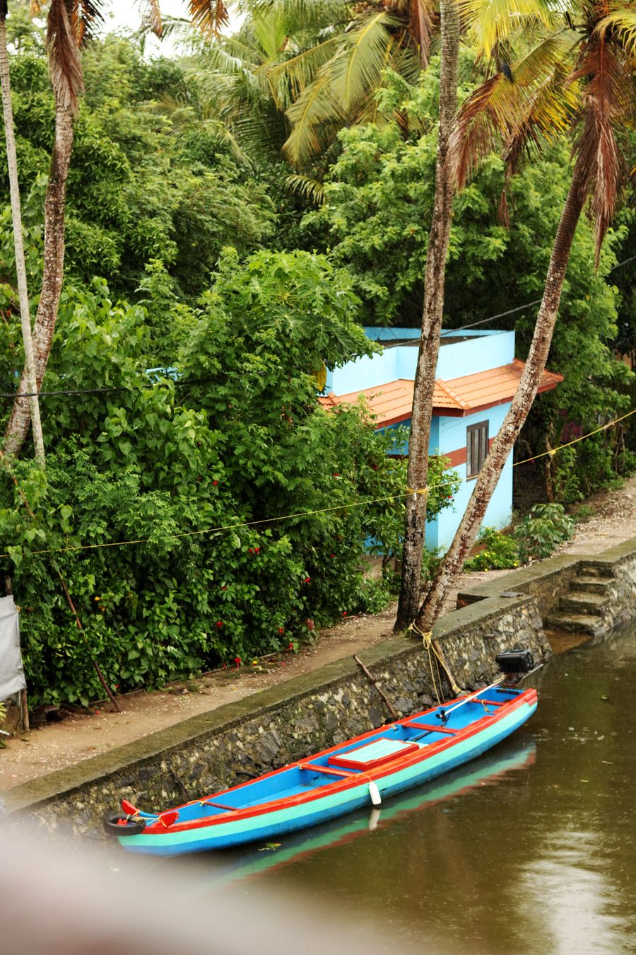A blue canoe on an Alappuzha canal