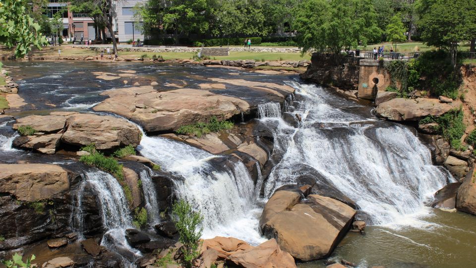 Falls Park on the Reedy waterfall in Greenville, South Carolina, with bridge and greenery.