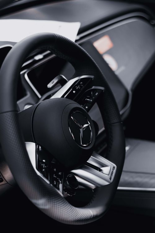 Free Close-up of a Mercedes-Benz steering wheel inside a luxury car, showcasing sleek design and modern details. Stock Photo