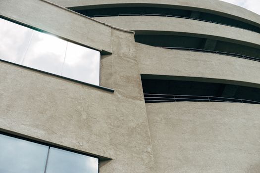 Close-up of a modern brutalist building featuring a rough concrete facade and reflective glass windows.. pexels, close, moder