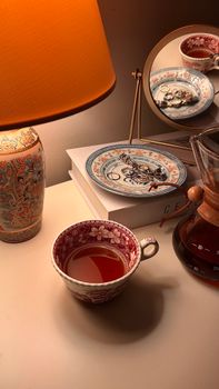 A cozy tea setup with vintage decor and warm lighting for a serene evening.
