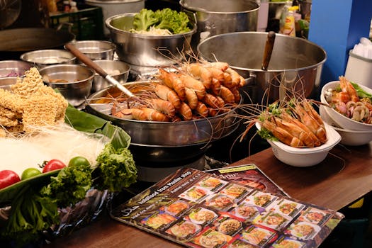 Vibrant display of Thai street food featuring fresh prawns, noodles, and produce.