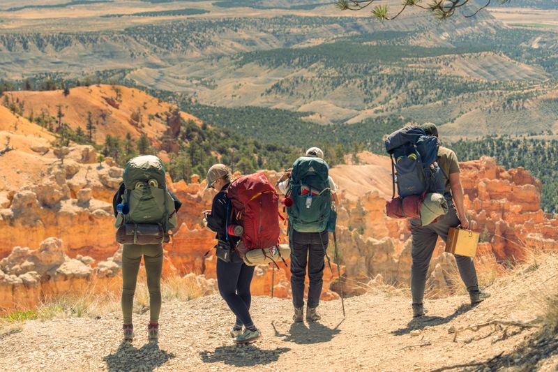 Backpackers at a scenic overlook in Bryce Canyon, Utah, enjoying stunning desert vistas.