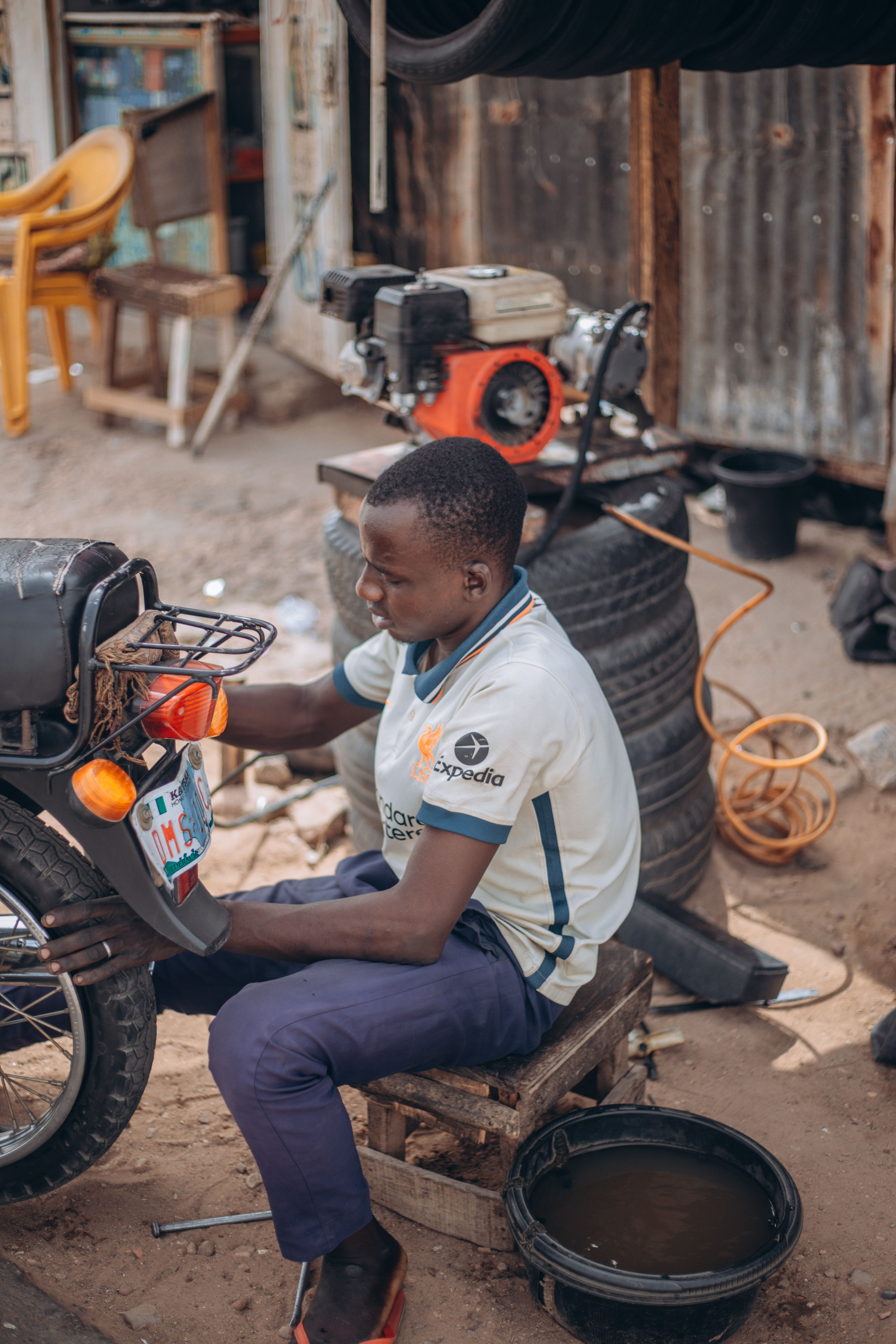 Young Mechanic Working on Motorbike Outdoors · Free Stock Photo
