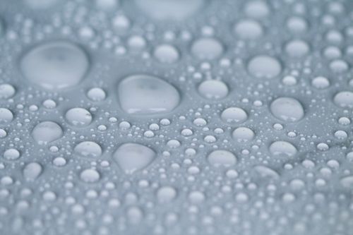 Free Detailed close-up macro image of water droplets on a smooth surface, showcasing texture and reflection. Stock Photo