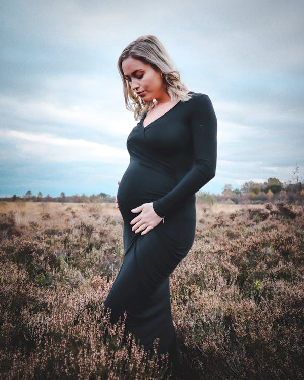 бесплатная Фотография беременной женщины в черном платье Стоковое фото