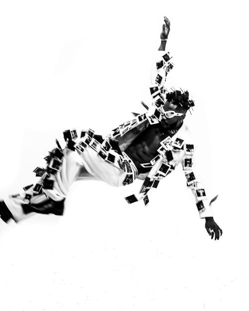 Free Striking black and white image of a person in motion, adorned in polaroids, creating an artistic statement. Stock Photo
