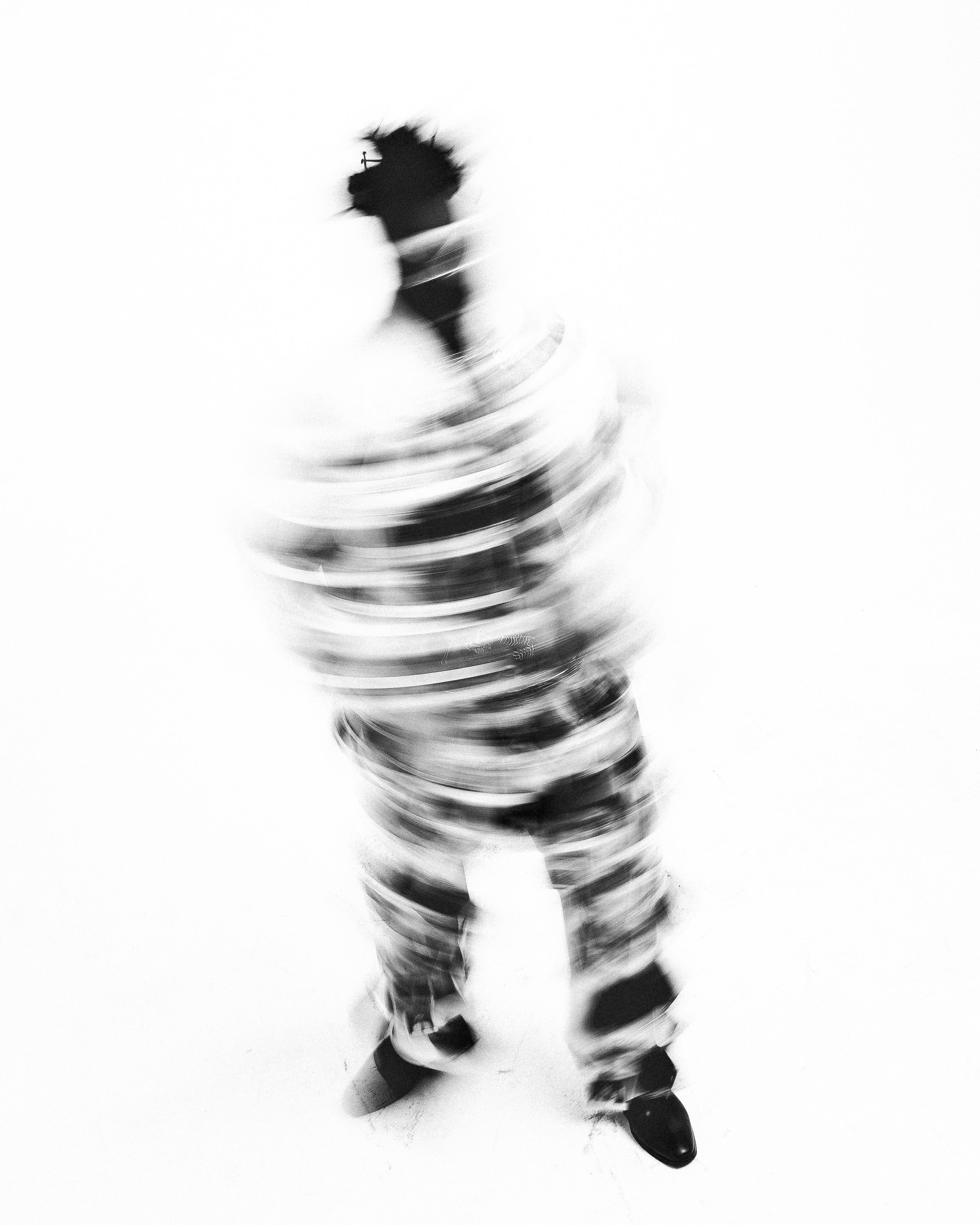 Artistic black and white motion blur capturing abstract movement of a person.