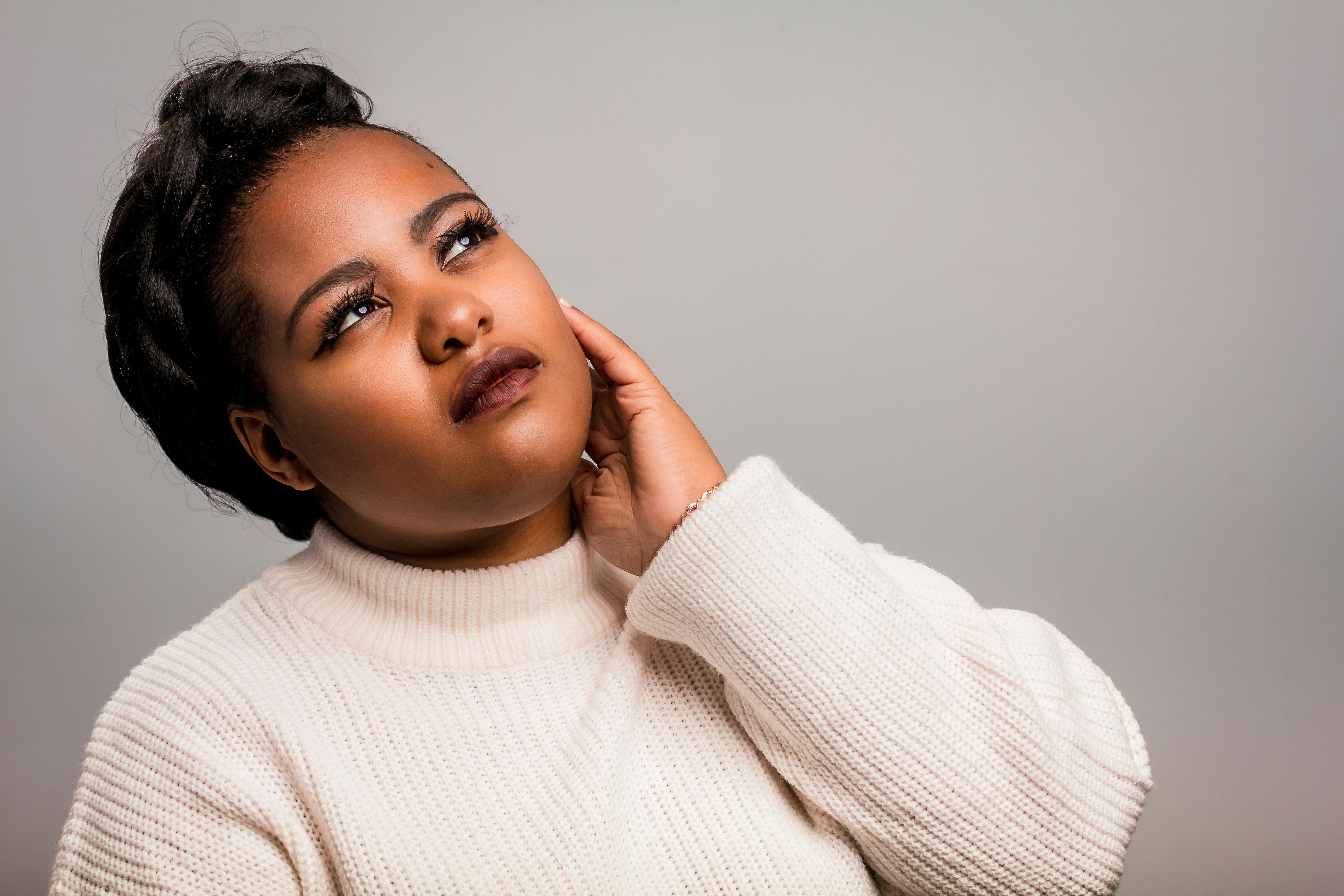 一位身着白色毛衣的女性，若有所思的时尚肖像，非常适合时尚或生活方式主题