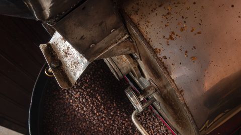 Top view of a coffee roasting machine with freshly roasted beans, ideal for coffee enthusiasts.