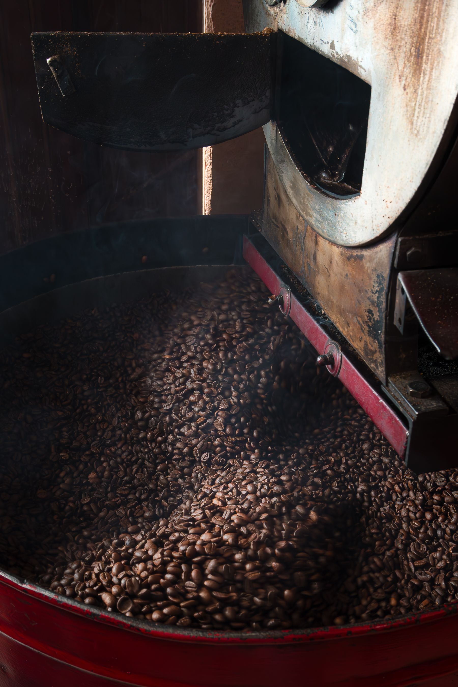Close-up of coffee beans being roasted in an industrial machine, highlighting the roasting process.