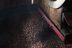 Close-up of coffee beans being roasted in an industrial machine, highlighting the roasting process.