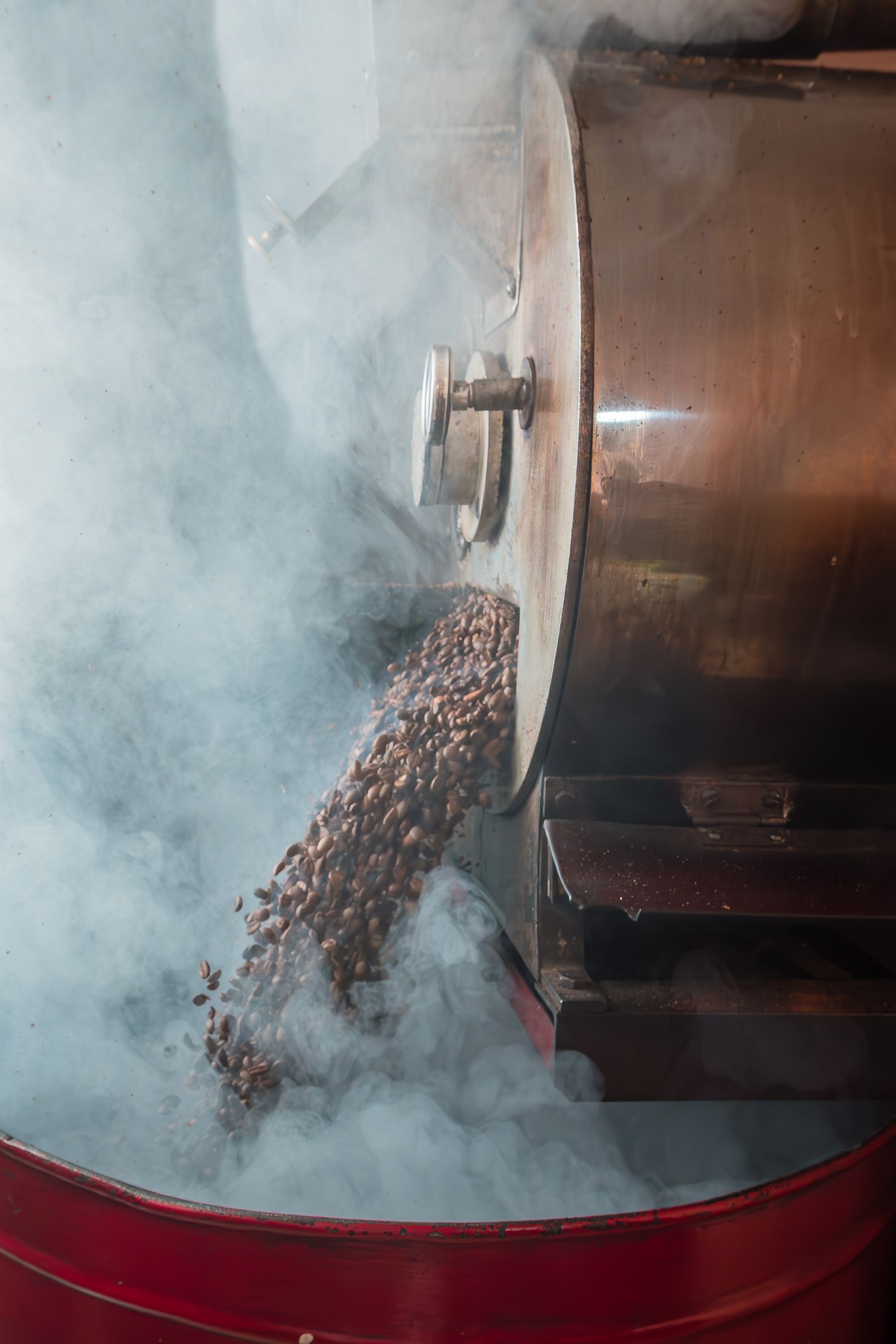 Coffee beans pouring from an industrial roaster