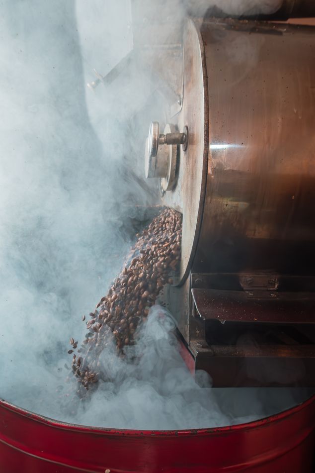 Koffiebrander in werking met rook en bonen