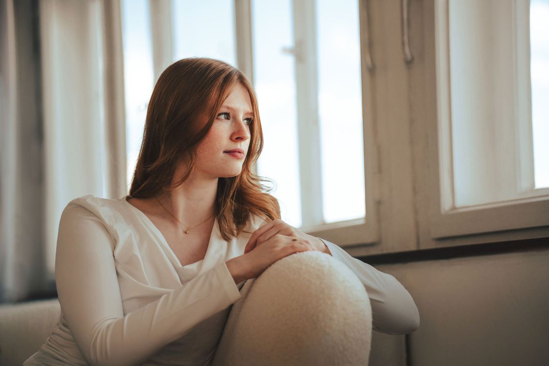 Contemplative Woman by a Window in Bremen · Free Stock Photo