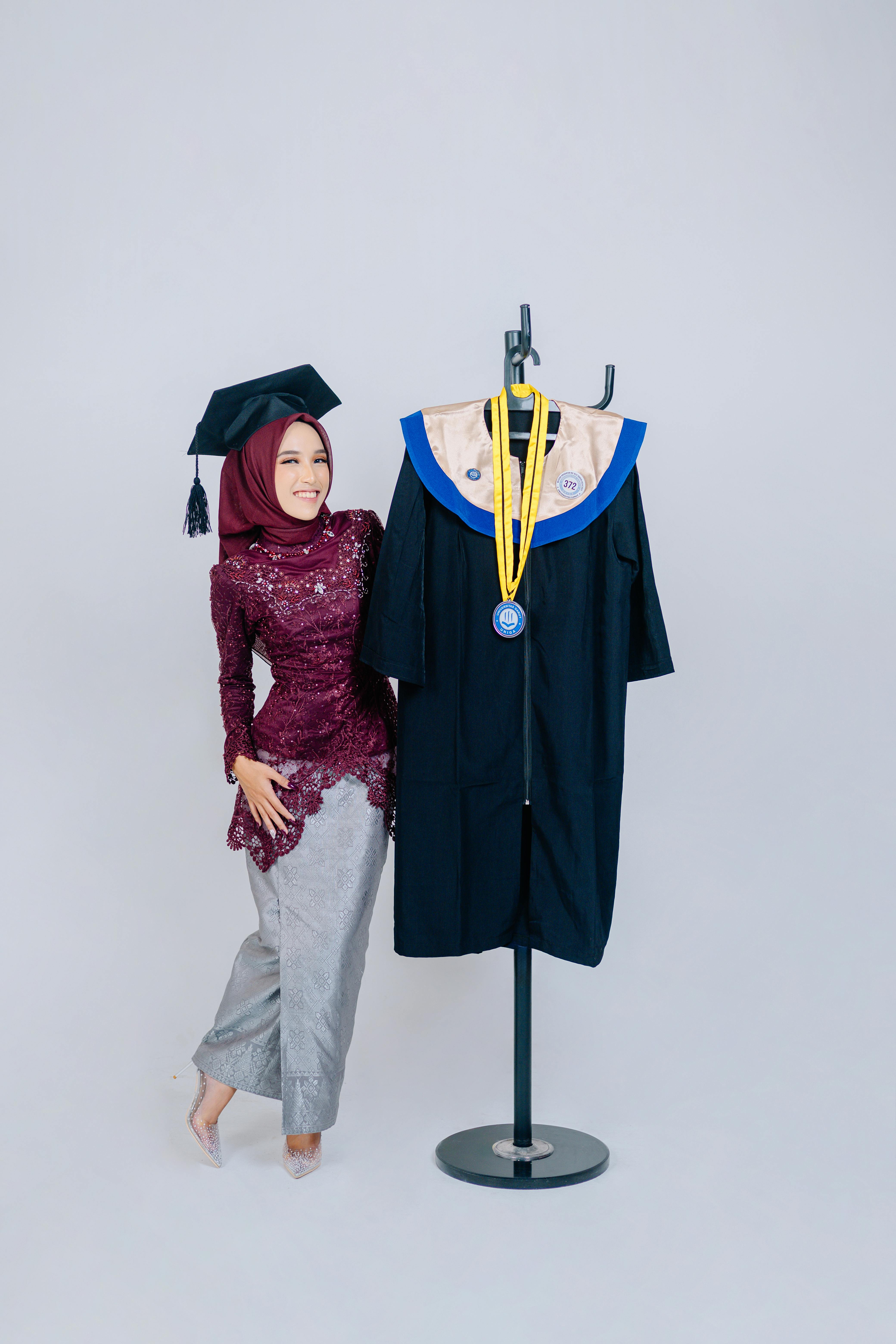 A proud graduate poses with her gown and medals, celebrating success.