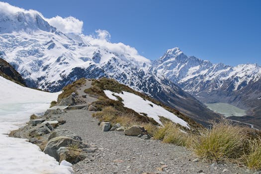 Breathtaking view of the snow-covered Mount Cook with a hiking trail in New Zealand's Canterbury region.
