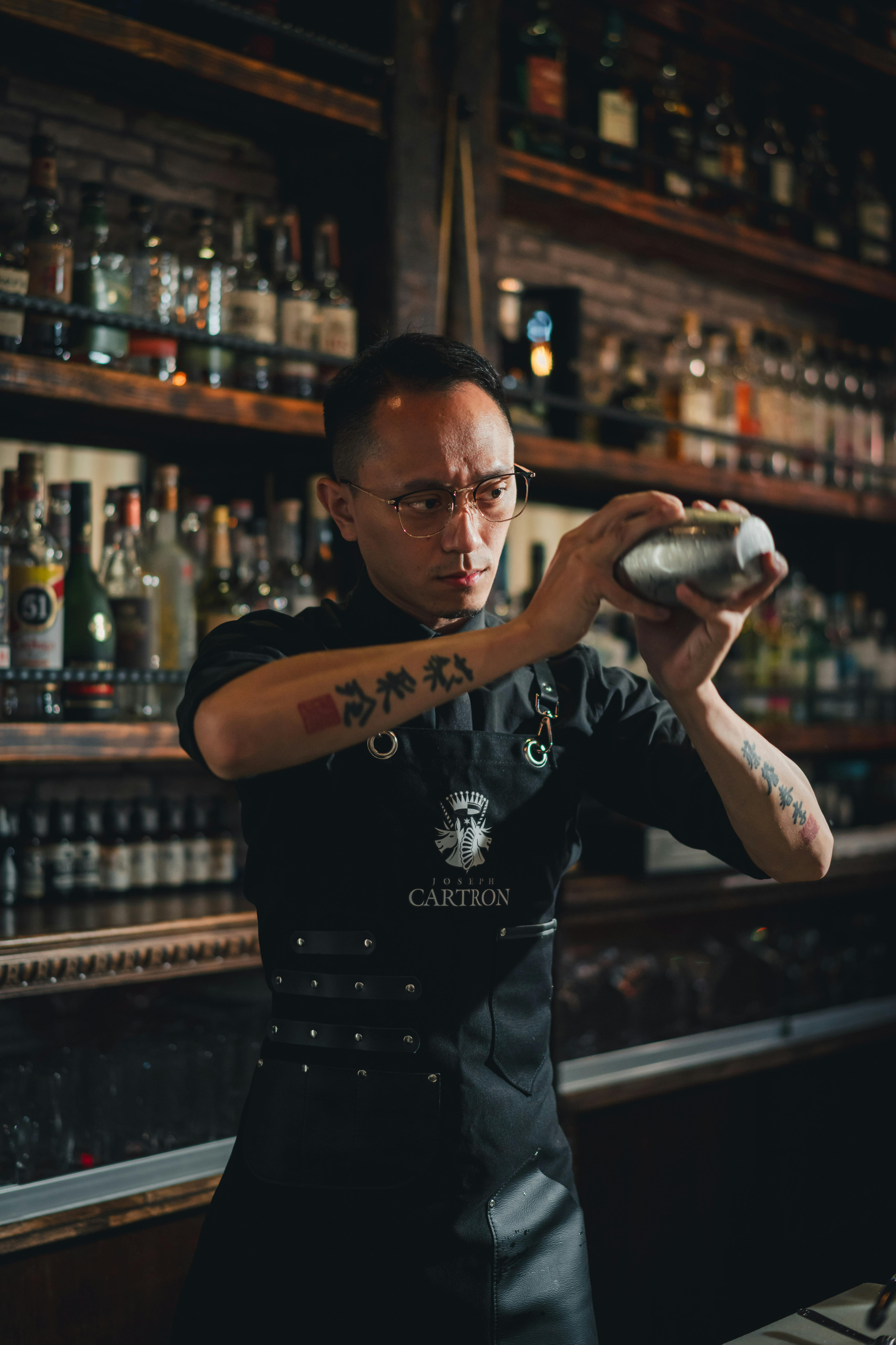 Gratis Profesjonell mixolog rister dyktig en cocktail på en trendy bar i Taiwan, og viser kunstnerisk sans og presisjon. Arkivbilde