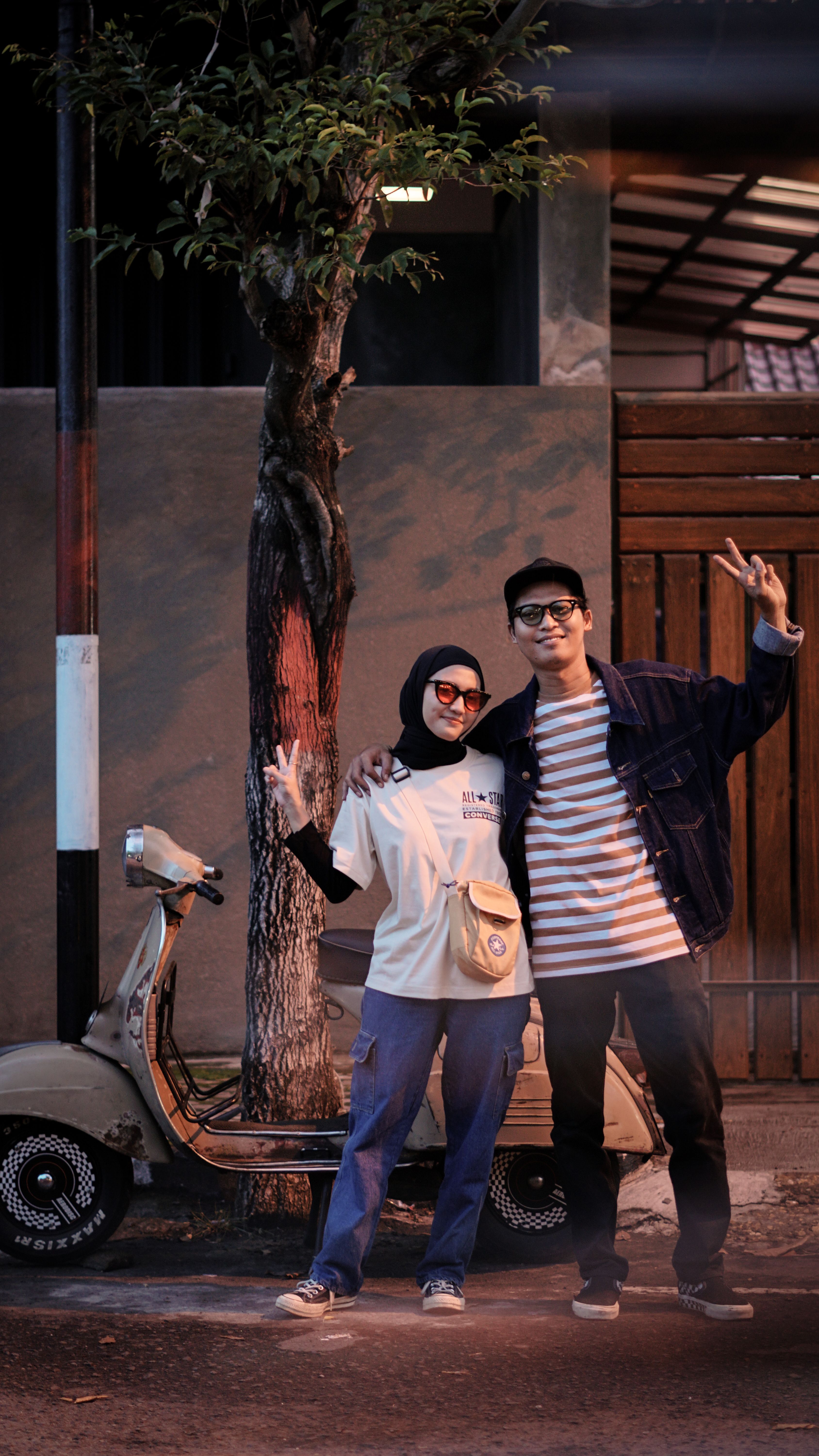 Happy couple in East Java, Indonesia, posing with a classic scooter during the day.