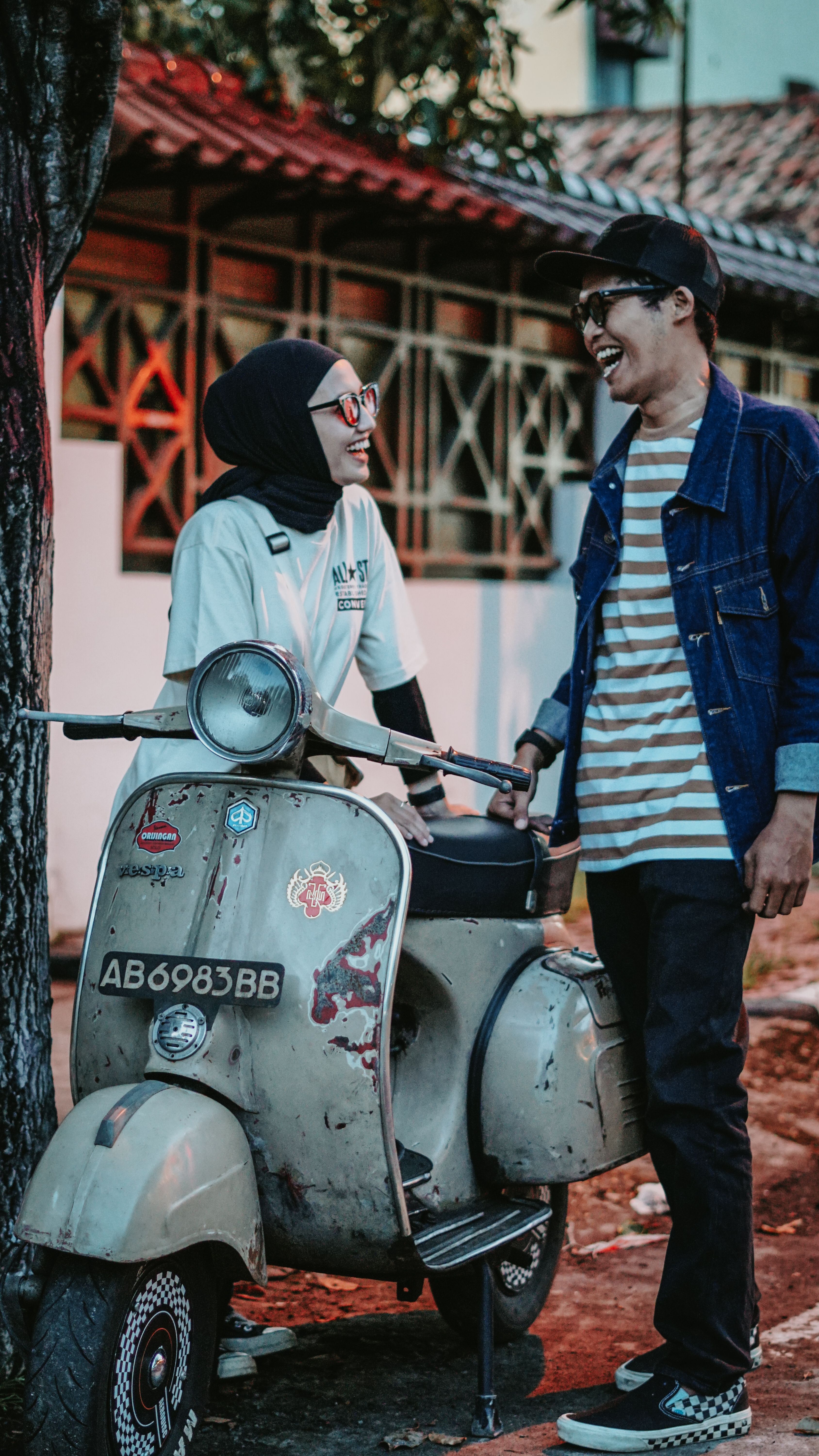 A playful couple enjoying a moment on a vintage Vespa, East Java, Indonesia.