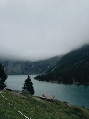 Mist-covered lake below forested mountains, photo by Vadim Malitskii on Pexels