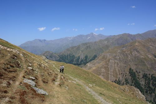 Free Hikers enjoying a scenic trek in the picturesque mountains under a clear blue sky. Stock Photo