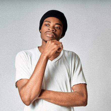 Model in a black beanie and white tee on a grey studio backdrop — photo by Hans Abdallah on Pexels