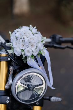 White rose bouquet decorates a motorcycle, offering a unique blend of elegance and adventure.