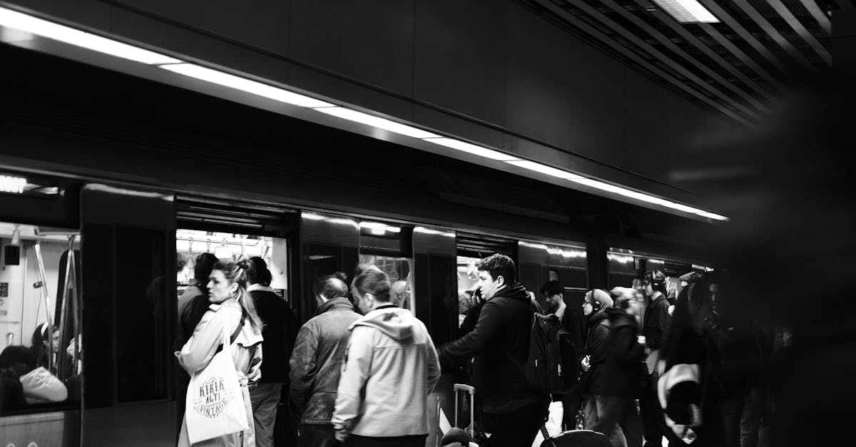 Monochrome view of a busy subway station with commuters boarding the train.