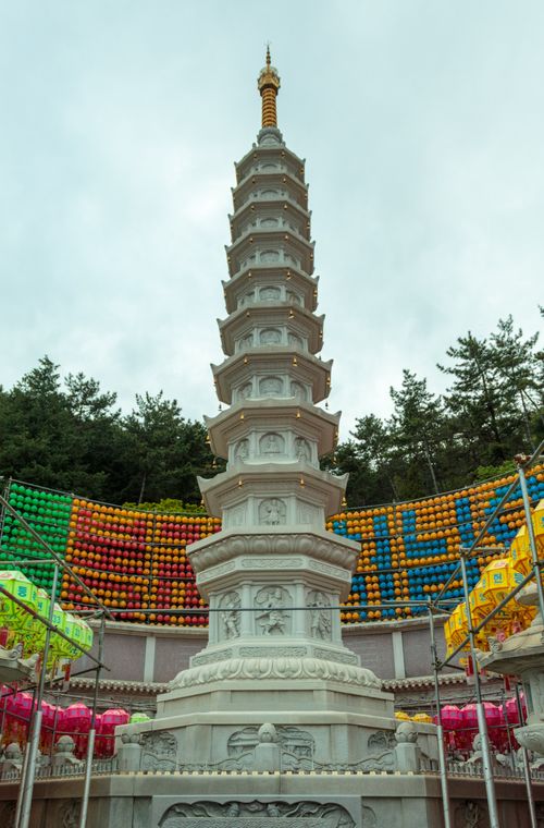 Free A striking tall pagoda surrounded by vibrant lanterns and lush greenery captures cultural essence. Stock Photo