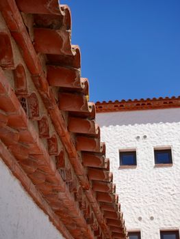Close-up of a Mediterranean-style building roof against a clear blue sky.