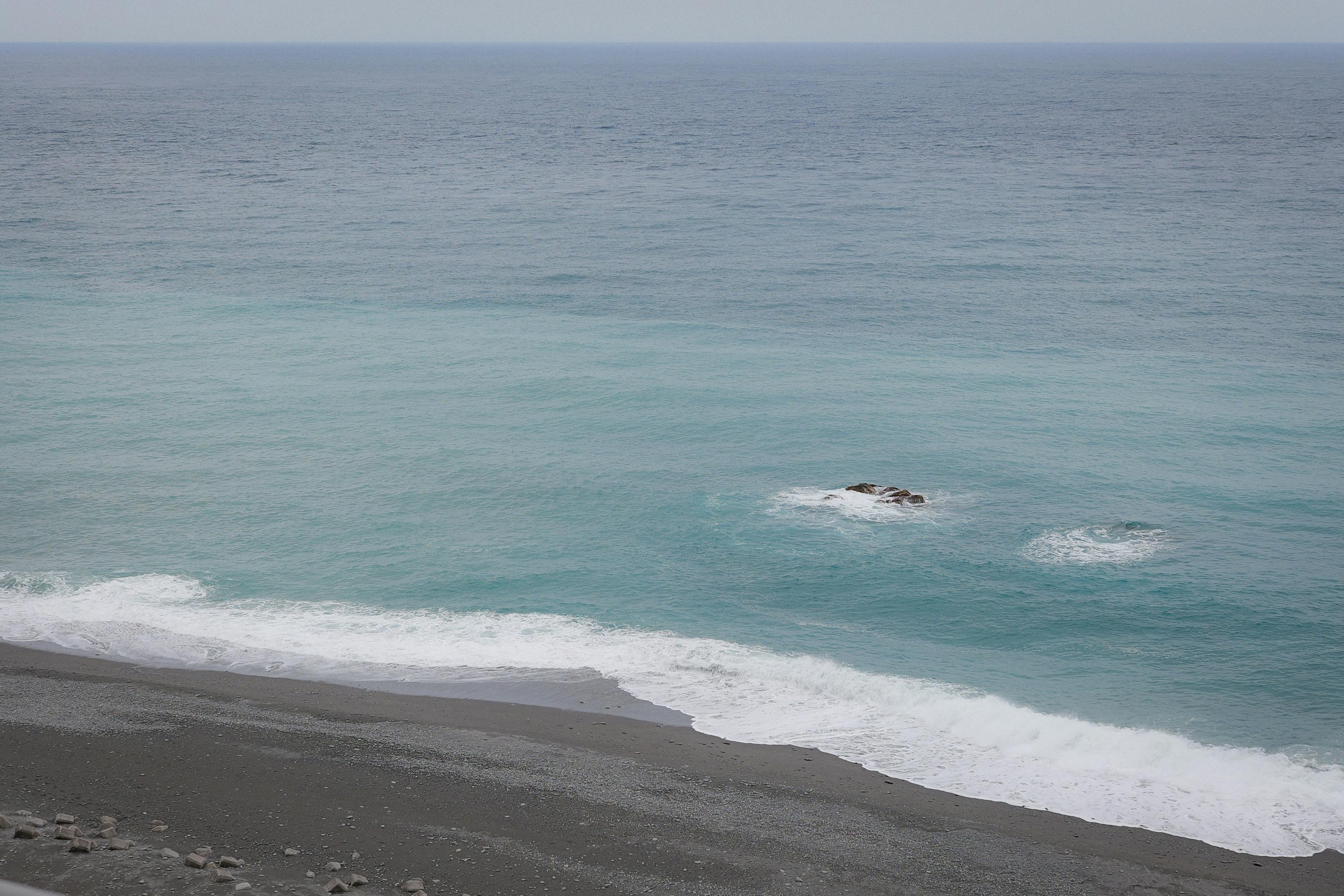 Beautiful coastal view of the Pacific Ocean from Taitung, Taiwan with clear blue waters and gentle waves.