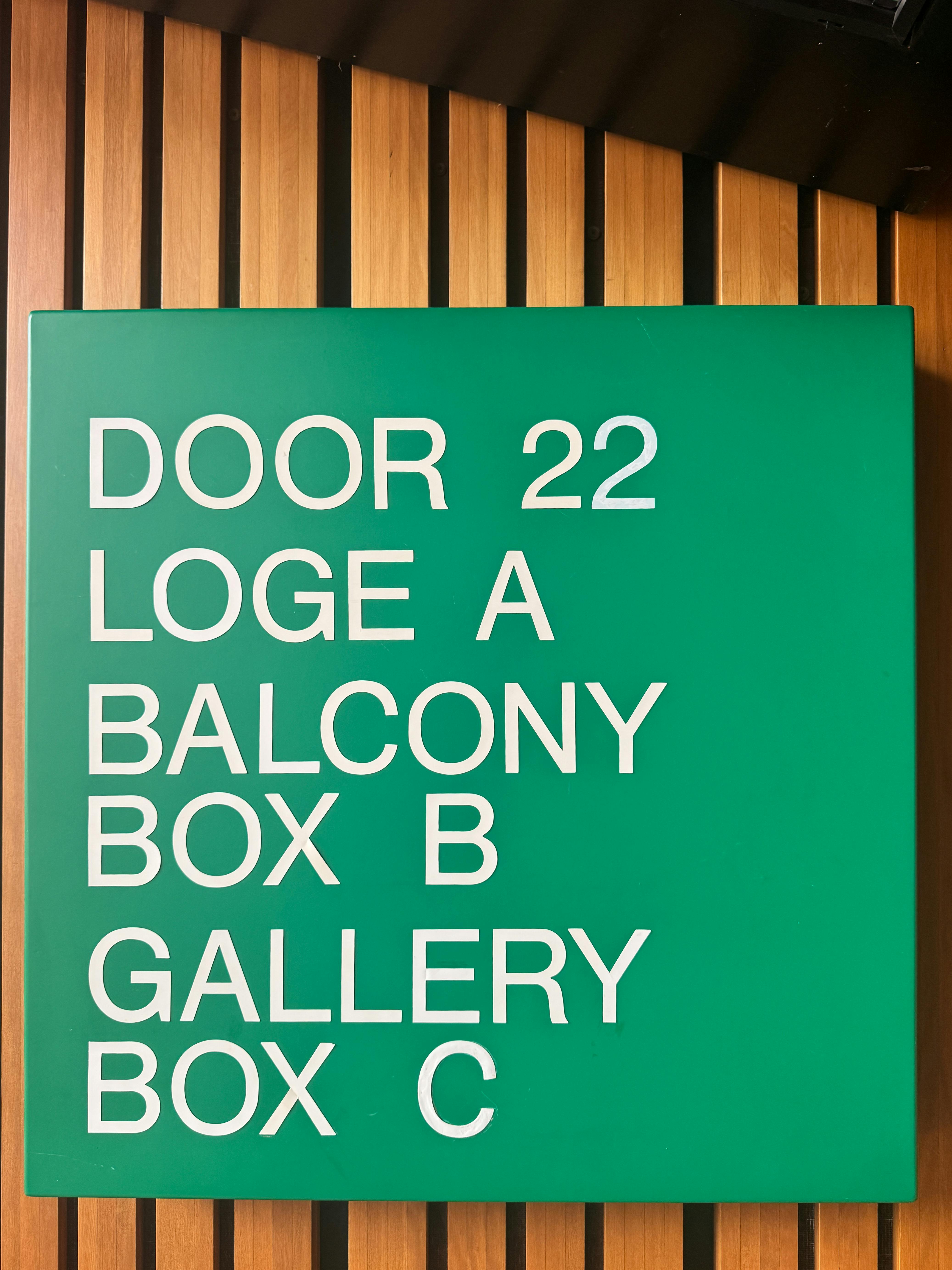 Free Bright green theater sign in Sydney showing seating directions. Stock Photo