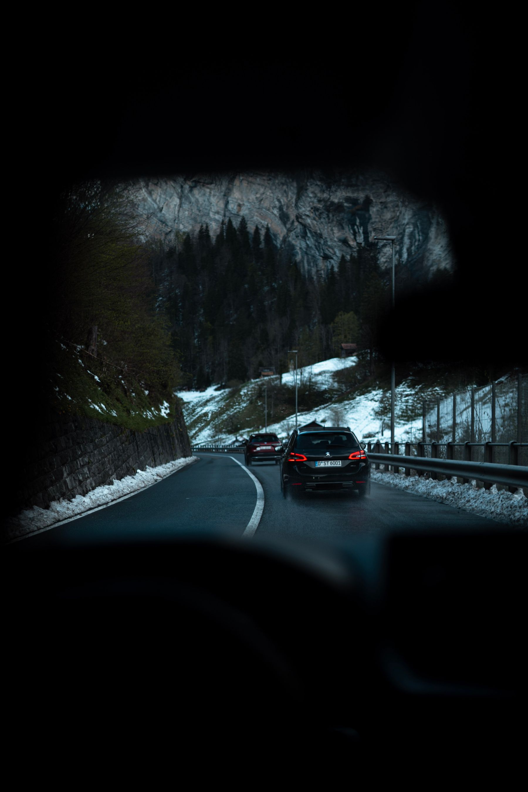 Fahrzeug auf einer Straße zwischen hohen Bergen.