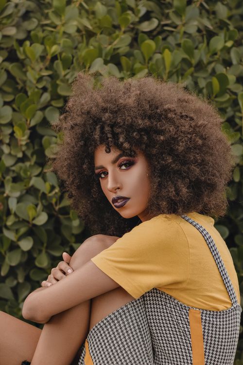 Free Beautiful woman with afro hairstyle posing outdoors, epitomizing beauty and fashion. Stock Photo