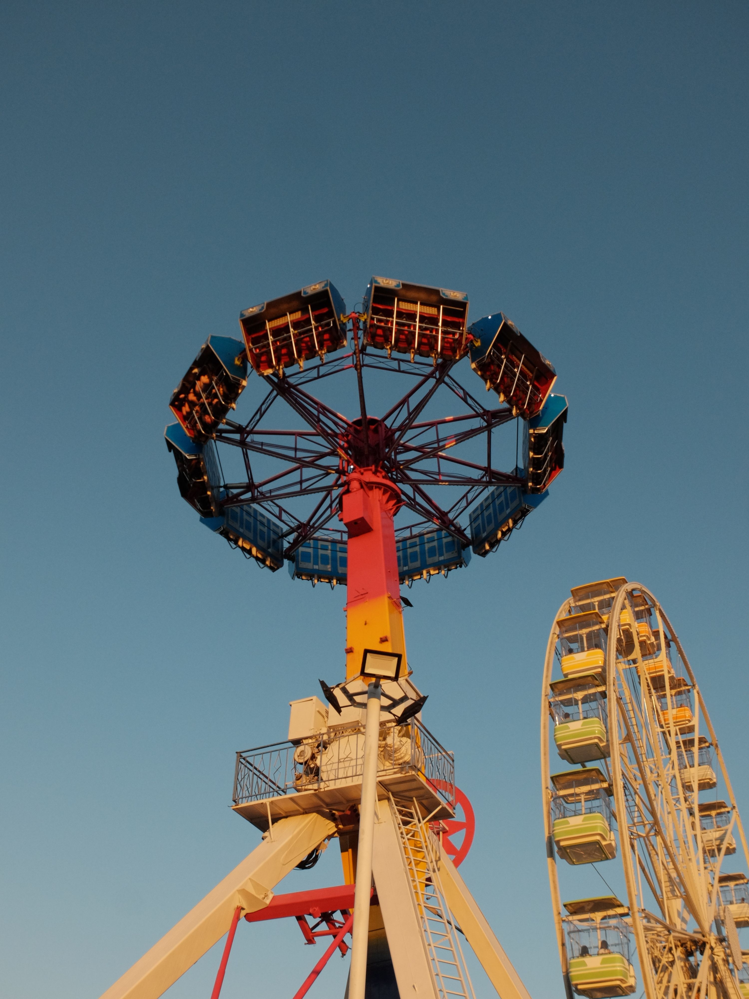 Vibrant Fairground Rides Against Sunny Sky · Free Stock Photo